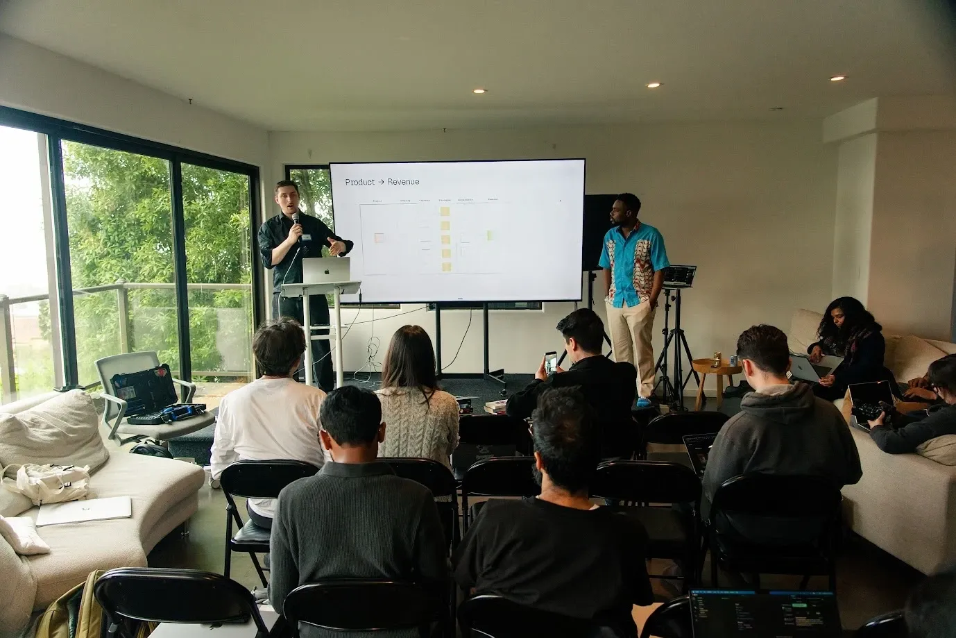 Roman presenting Product → Revenue to the room at AGI House